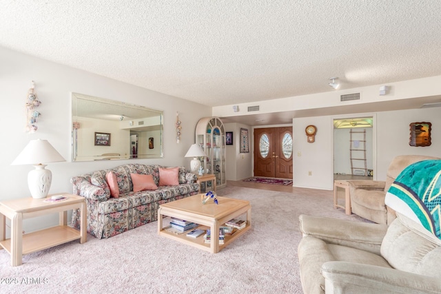 living area featuring carpet floors, visible vents, and a textured ceiling