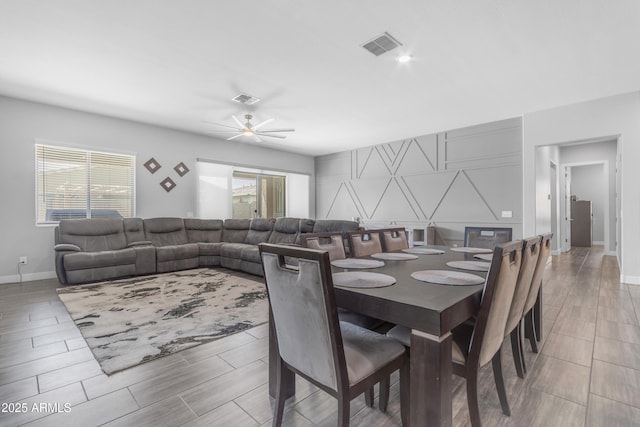 dining area featuring baseboards, visible vents, wood tiled floor, and ceiling fan
