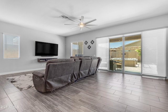 living area with wood tiled floor, ceiling fan, baseboards, and visible vents