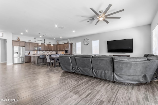 living room with ceiling fan, wood finished floors, and recessed lighting