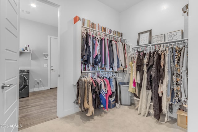 spacious closet with visible vents, carpet, and washer / dryer