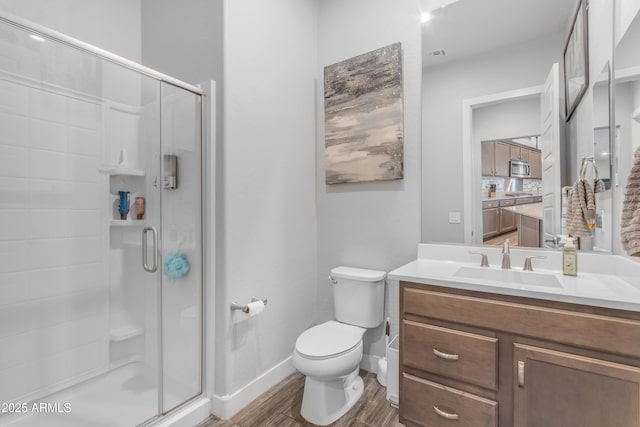 bathroom featuring a shower stall, toilet, and wood finished floors