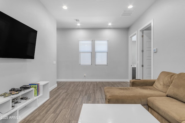 living area with recessed lighting, visible vents, and light wood finished floors