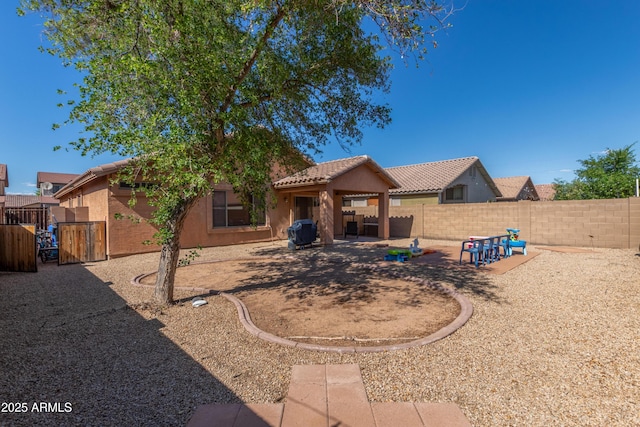 4817 W St Charles Ave, Laveen, AZ 85339 - rear view of house featuring stucco siding, a fenced backyard, a tile roof, and a patio area