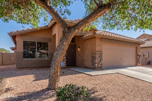 4817 W St Charles Ave, Laveen, AZ 85339 - view of front of home featuring a garage, concrete driveway, stucco siding, and a tile roof