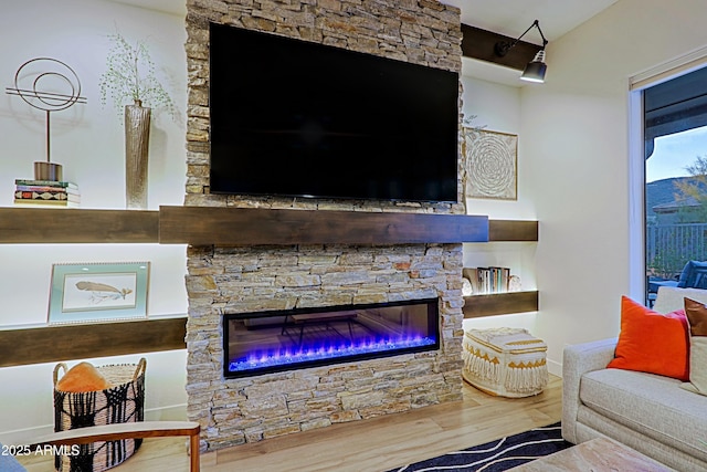 living area featuring a glass covered fireplace and wood finished floors