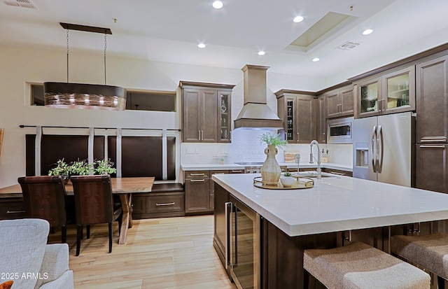 kitchen featuring recessed lighting, a sink, beverage cooler, stainless steel appliances, and premium range hood
