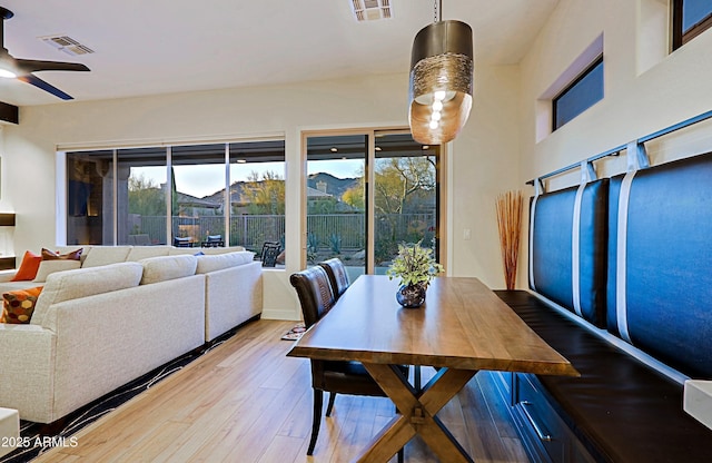 dining space with wood finished floors, ceiling fan, and visible vents