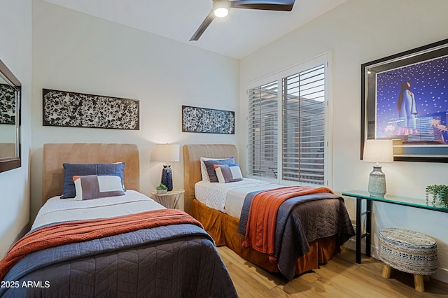 bedroom with a ceiling fan, wood finished floors, and lofted ceiling