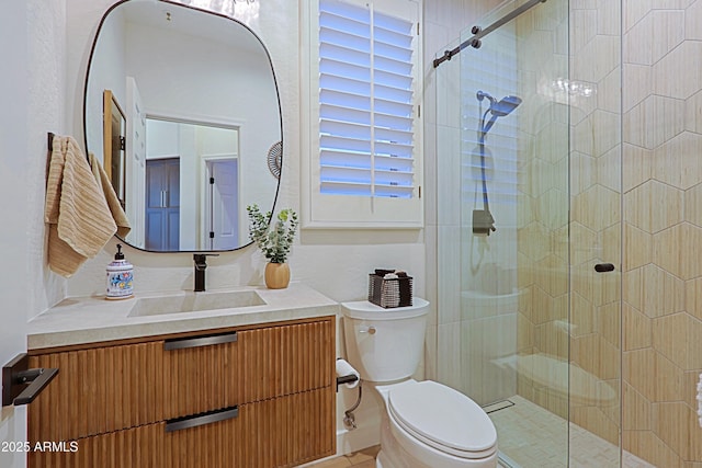 full bathroom featuring a shower stall, vanity, and toilet