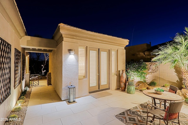 patio at twilight with french doors and fence