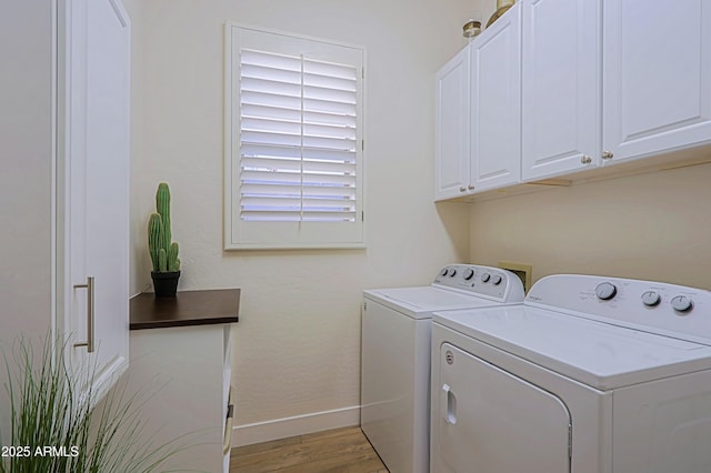 washroom featuring cabinet space, independent washer and dryer, baseboards, and light wood-style flooring