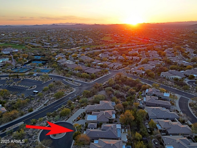 aerial view at dusk featuring a mountain view and a residential view