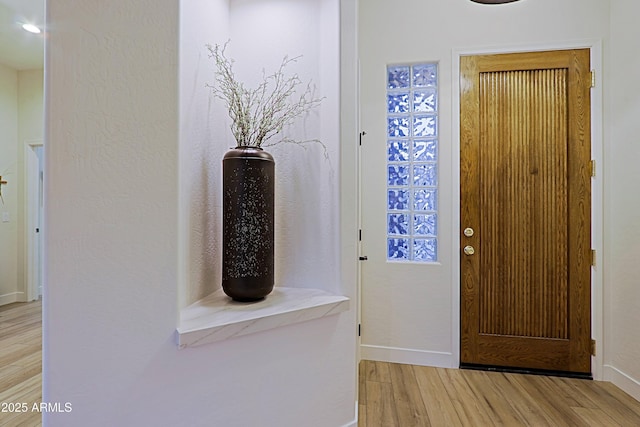 entrance foyer with baseboards and light wood-type flooring