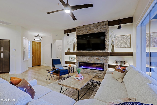 living room with ceiling fan, light wood-type flooring, baseboards, and a fireplace