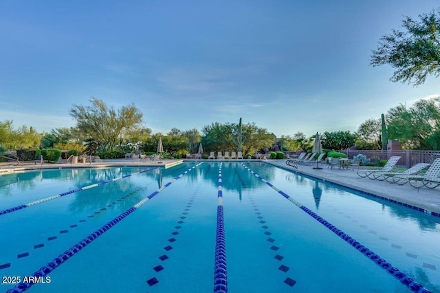 community pool with a patio and fence