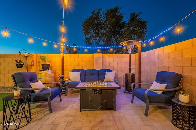 patio at twilight featuring an outdoor living space with a fire pit