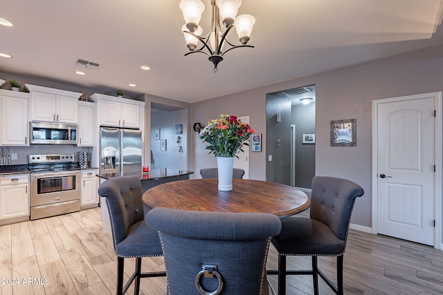 dining space with a chandelier and light hardwood / wood-style floors