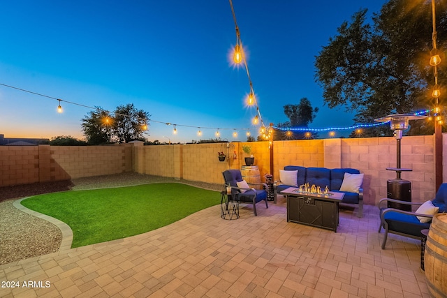 patio terrace at dusk with an outdoor living space with a fire pit