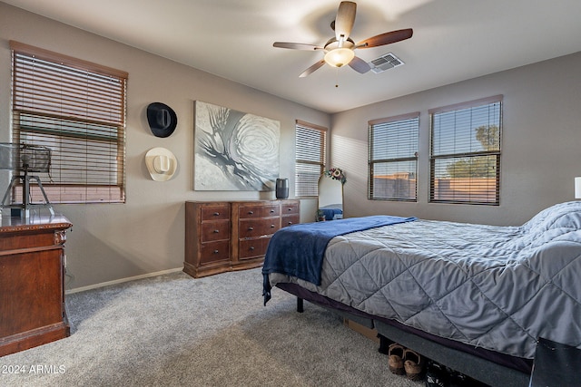 carpeted bedroom with multiple windows and ceiling fan