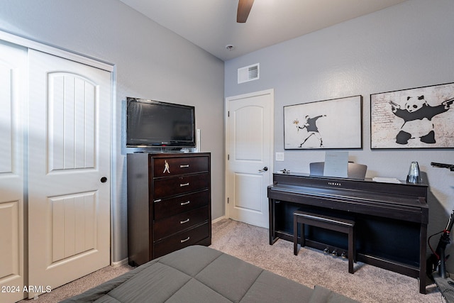 interior space with ceiling fan, light carpet, and a closet