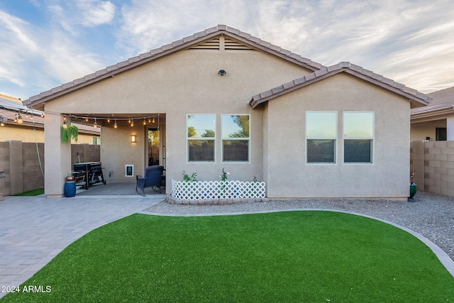 back of property with a patio area and a yard