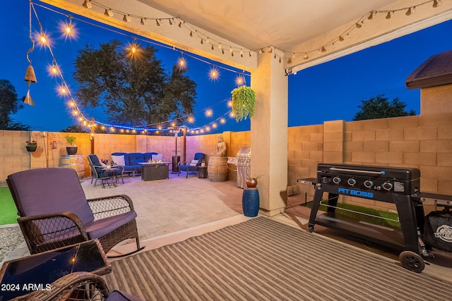 patio at twilight featuring an outdoor kitchen and an outdoor hangout area