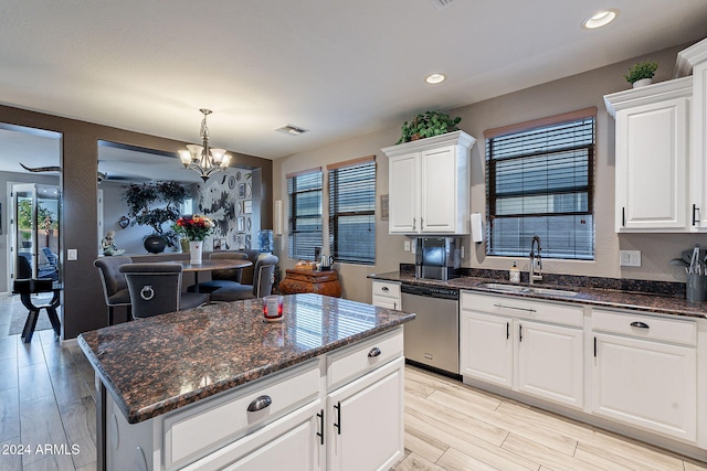 kitchen with dishwasher, white cabinets, sink, light hardwood / wood-style flooring, and a kitchen island