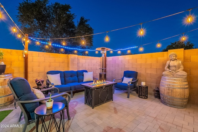 patio at twilight featuring an outdoor living space with a fire pit