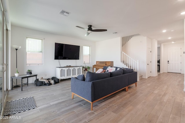 living room featuring ceiling fan and light wood-type flooring