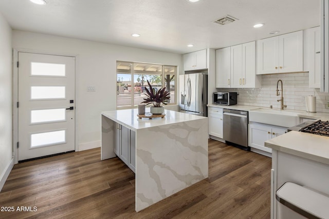 8022 E Columbus Ave, Scottsdale, AZ 85251 - kitchen with stainless steel appliances, a center island, dark wood-type flooring, backsplash, and recessed lighting