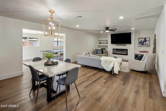 8022 E Columbus Ave, Scottsdale, AZ 85251 - dining room with a glass covered fireplace, wood finished floors, recessed lighting, built in features, and a ceiling fan