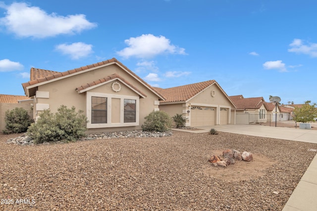 view of front of property featuring a tile roof, an attached garage, fence, and stucco siding