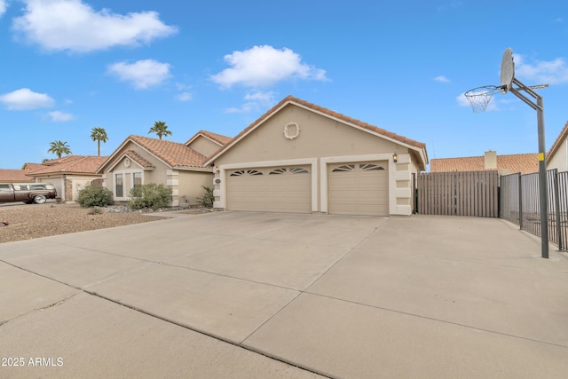 view of front of home featuring fence, an attached garage, stucco siding, concrete driveway, and a tiled roof