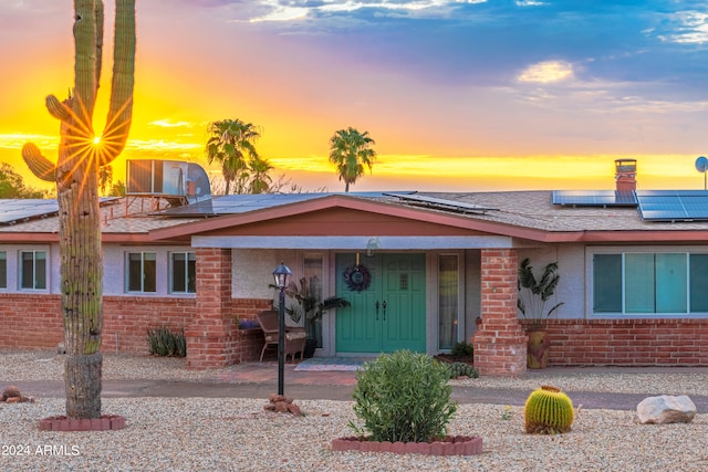 ranch-style home featuring solar panels