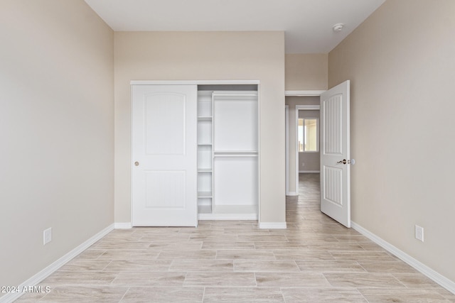 unfurnished bedroom with light hardwood / wood-style flooring and a closet