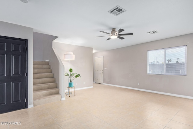 empty room with ceiling fan and light tile patterned flooring