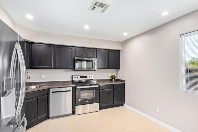 kitchen featuring light tile patterned flooring, stainless steel appliances, and sink