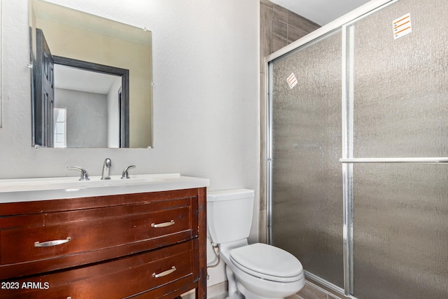 bathroom featuring vanity, toilet, and an enclosed shower