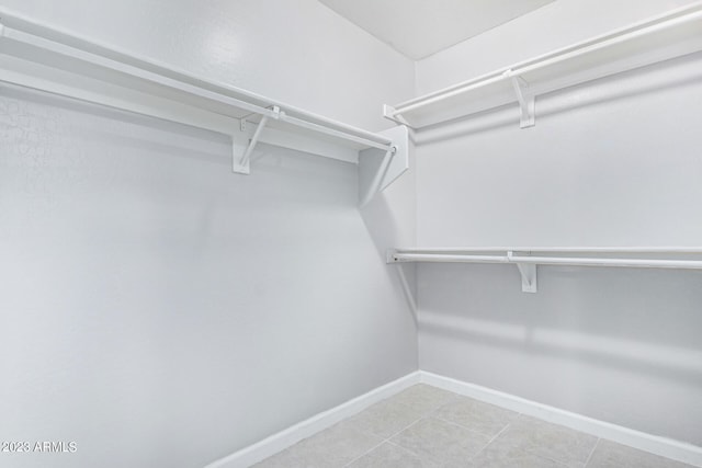 walk in closet with light tile patterned floors