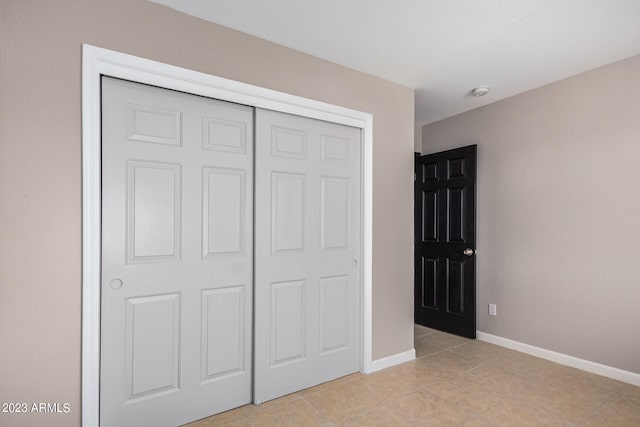 unfurnished bedroom with a closet and light tile patterned flooring