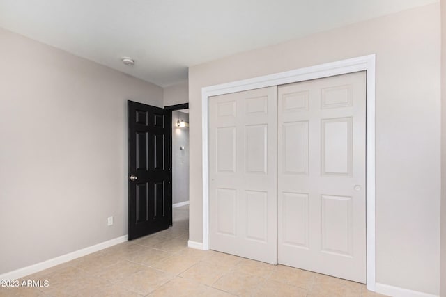 unfurnished bedroom featuring a closet and light tile patterned floors