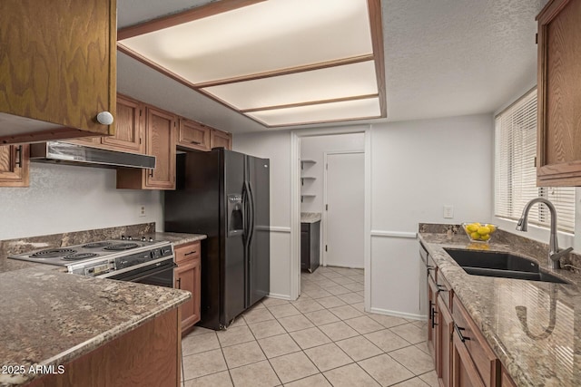 kitchen with range with electric cooktop, brown cabinetry, dark stone counters, black fridge with ice dispenser, and a sink