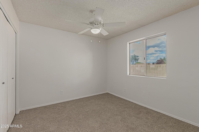 spare room featuring a ceiling fan, carpet, a textured ceiling, and baseboards