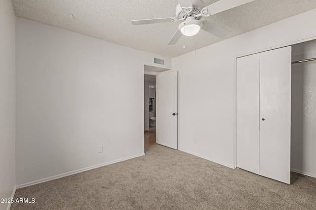 unfurnished bedroom featuring baseboards, visible vents, a textured ceiling, carpet flooring, and a closet