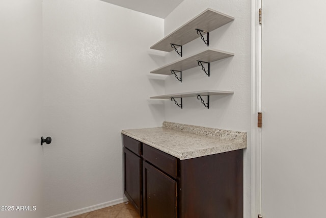 bar featuring baseboards and light tile patterned flooring