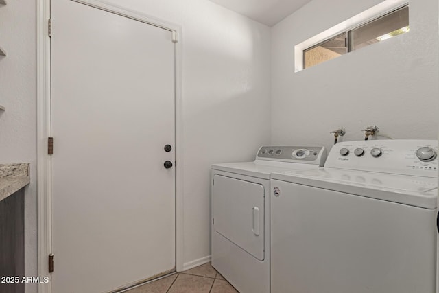 clothes washing area with light tile patterned floors, laundry area, and separate washer and dryer