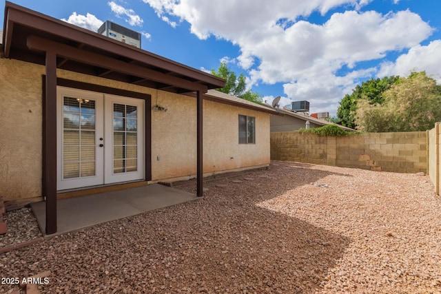 view of yard with a patio, fence, cooling unit, and french doors