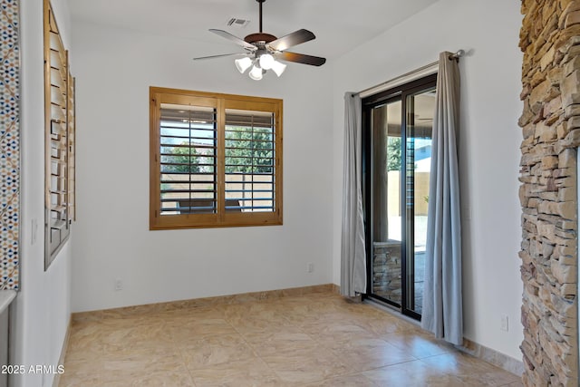 tiled empty room featuring ceiling fan