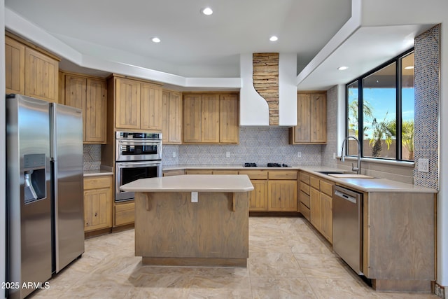 kitchen featuring wall chimney exhaust hood, sink, backsplash, a center island, and stainless steel appliances